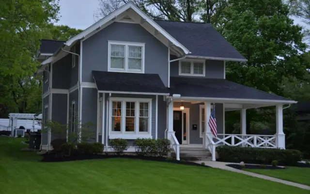 Rain gutter and downspout on a shingled roofline