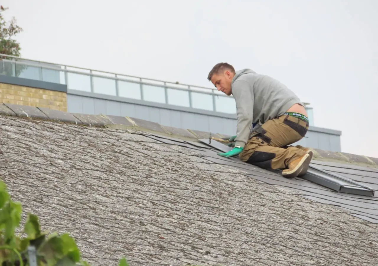 Roofer working on an asphalt shingle roof repair