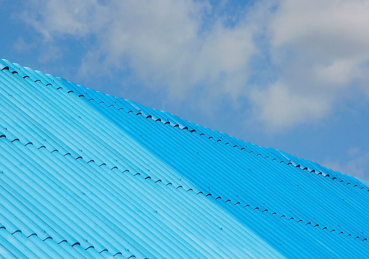 Light blue corrugated metal roof beneath a cloudy sky