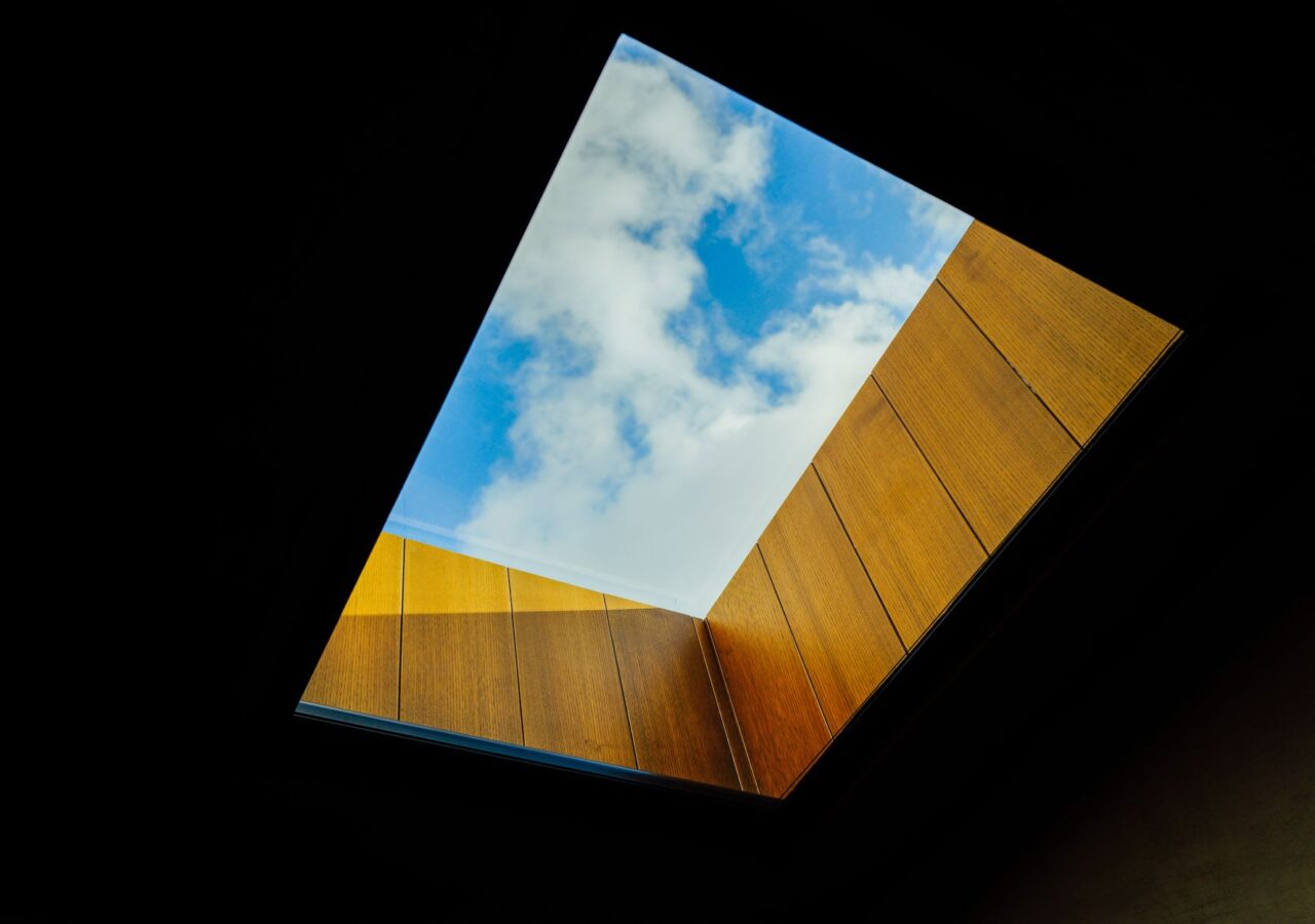 Skylight framed in wood, open to a blue sky