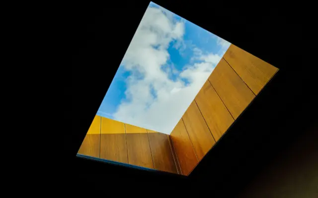 Skylight framed in wood, open to a blue sky
